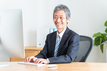 パソコン作業をするシニア日本人男性
