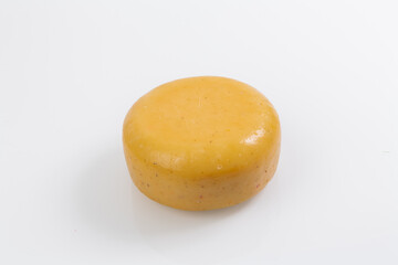 A piece of fresh processed cheese isolated on a white background