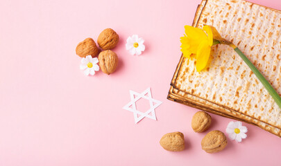 Passover Greeting Card with Matzah, Nuts and Spring Flowers on Pink Background.