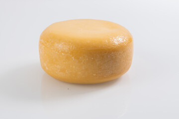 A piece of fresh processed cheese isolated on a white background