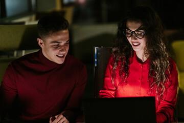 Lovely business couple working late night at the office and having fun conversation. Close up photo