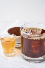 Popular cocktail called carajillo made with espresso, liquor and ice on white marble table