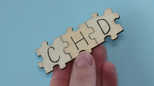 CHD word written on wooden puzzles on blue background. Healthcare conceptual for hospital, clinic and medical busines. CHD acronym coronary heart disease