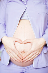 Close-up of Pregnant woman keeping her hands on belly.