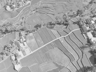 A black and white photo with a contrast between dense settlements and large rice fields in the Bandung area - Indonesia.