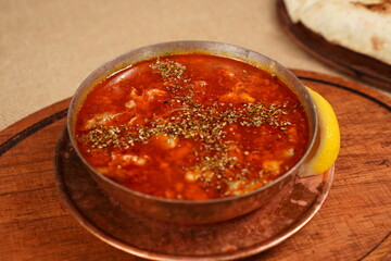 Turkish Traditional Soup with bread on dark rustic wooden background, kelle, paca corbasi. Close angle 