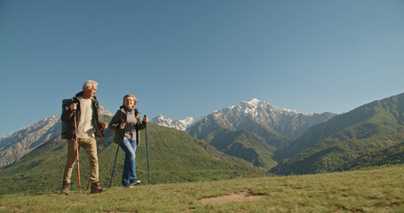 Fototapeta na wymiar Mature caucasian couple on vacation, having a hike in spring mountains, spending time together after retirement together travelling - tourism, pension concept