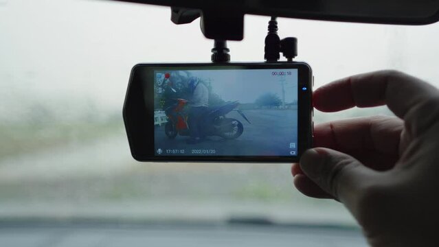 Smart driver checking video recorder in the car before driving, dash cam digital for safety road in traffic accident, Cam front windshield record traffic ahead and navigation.