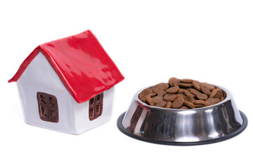 adopt a pet toy ceramic house with red roof and metal bowl of dry food on white background