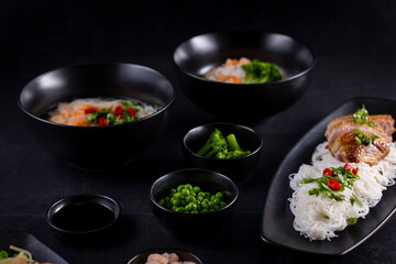Various dishes of Asian cuisine with different types noodles and rice with shrimp, duck, vegetables and black sesame