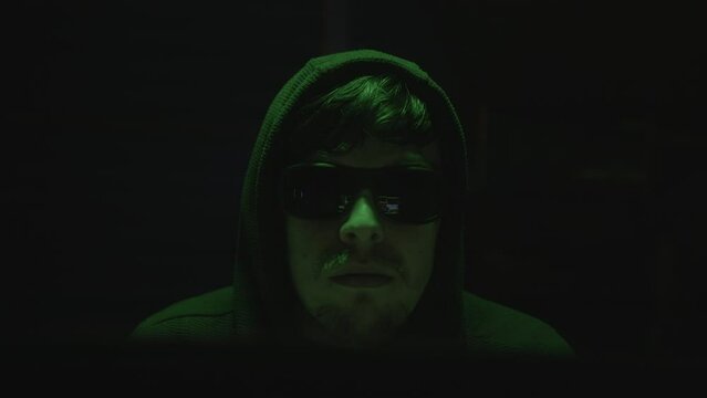 Mysterious Young Hacker Takes off Black Glasses and Looks Directly at Camera, Close-up Shot