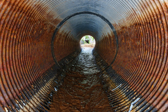 Exploring the Depths of a Rusty Drainage Pipe