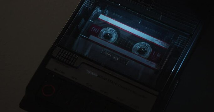 Close-Up Of Tape Being Loaded Into Cassette Recorder Under Cold Low-Key Light
