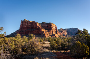 Vibrant red rocks of Courthouse Butte in the morning sun, Sedona, Arizona, USA. Scenic landscape with the famous geological formations under a sunny blue sky. Popular hiking trail in teh United States