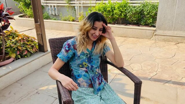 The woman listens to the interlocutor with a smile and nod her head outdoor