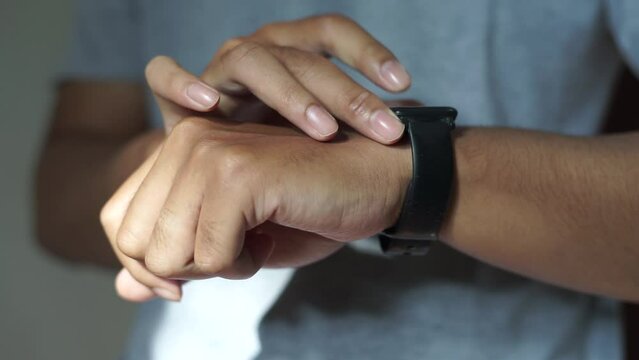 A man press and touch smartwatch screen button on left hand wrist