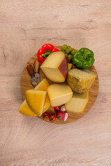 Bosnian traditional cheese served on a wooden container with peppers, parade and onions isolated on a white background