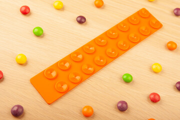 image of antistress silicon toy candies wooden desk  background 