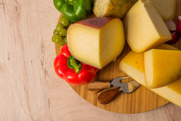 Bosnian traditional cheese served on a wooden container with peppers, parade and onions isolated on a white background