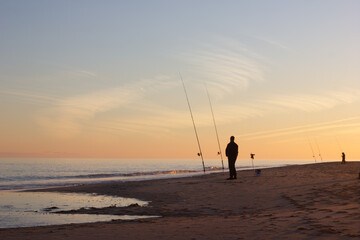 Man fishing on the beach at sunset. Beautiful natural landscape in Tavira.