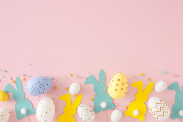 Easter decor concept. Top view photo of yellow blue white eggs easter bunny toppers and sprinkles...