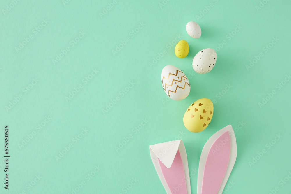 Wall mural easter concept. top view photo of easter bunny ears yellow white eggs on isolated teal background wi