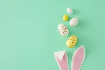 Fotobehang Easter concept. Top view photo of easter bunny ears yellow white eggs on isolated teal background with copy space. Holiday card idea © Goncharuk film