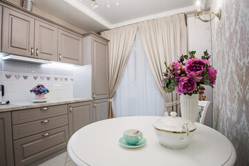 Kitchen room. White table and flowers