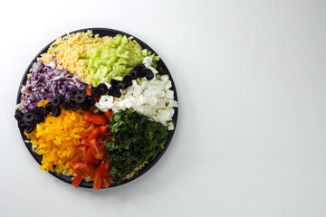 Sliced vegetables, orzo pasta, mozzarella, basil on a large plate.