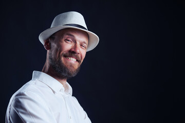 Portrait of smiling middle age man in straw hat looking at camera