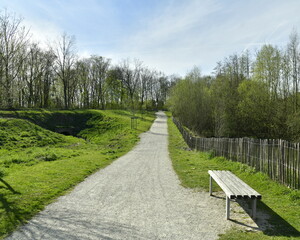 Chemin en gravier clair longeant bois et plans d'eau au parc du Paradis à Braine-l'Alleud 