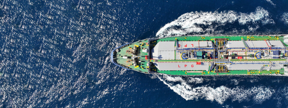 Aerial drone ultra wide top view photo of industrial liquified LPG gas tanker cruising near gas terminal