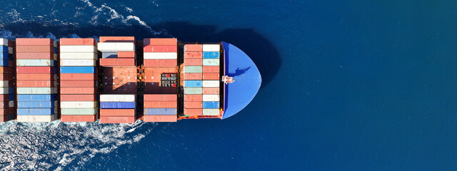 Aerial drone ultra wide panoramic photo of container tanker ship carrying truck size colourful...