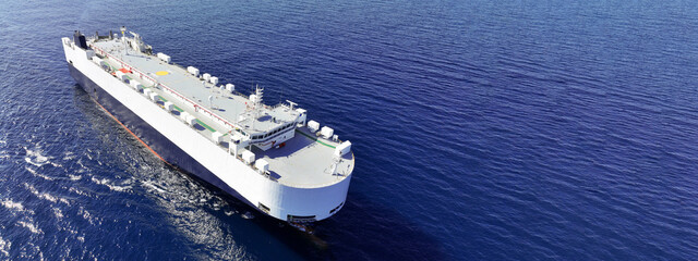 Aerial drone ultra wide panoramic photo of huge car carrier ship RO-RO (Roll on Roll off) cruising in Mediterranean deep blue Aegean sea © aerial-drone