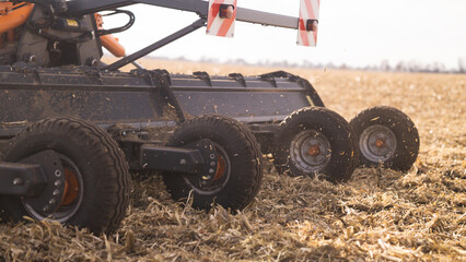 Green tractor mulching corn at sunset