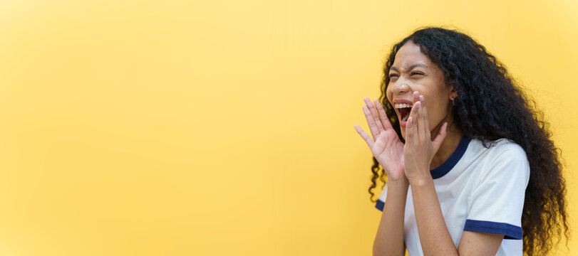 Cheerful Black - American African Woman Yelling With Hands Close Up On Yellow Background. Happy Beautiful Girl Using Hands At Mount While Screaming, Woman Speaking Louder. Advertising Concept.