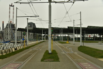 Ligne du Tram de la Côte avec ses caténaires reliant toutes les cités balnéaires belges sous un ciel sombre à Ostende  - obrazy, fototapety, plakaty