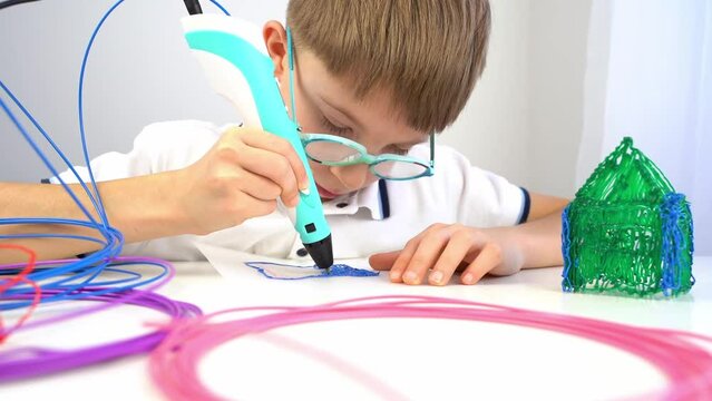 a boy draws with a 3d pen, additional classes and the concept of modern education for children
