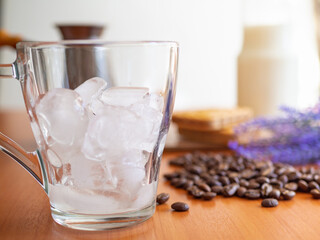 a glass of ice and coffee beans on a table, Cookies and milk bottle on background