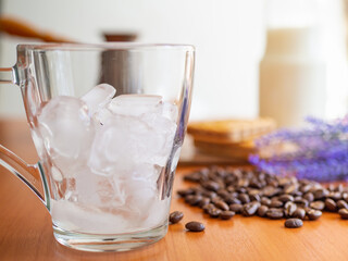 a glass of ice and coffee beans on a table, Cookies and milk bottle on background