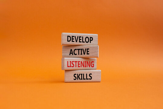Listening skills symbol. Concept word Develop active listening skills on wooden blocks. Beautiful orange background. Business and Develop active listening skills concept. Copy space