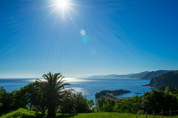 Fototapeta na wymiar Seascape blue sky bright sun at the zenith, Atlantic Ocean Basque Country, Spain.