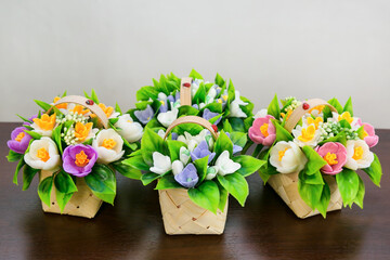 Crocuses, daffodils, handmade soap snowdrops in wicker baskets on a white background.