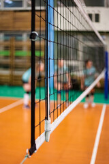 Sports image background for team volleyball games: volleyball game and net in an old school sport gym, selective focus. Concept of getting sport, healthy lifestyle and team success. Copy ad text space