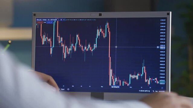 Man checking Bitcoin price chart on digital stock market on laptop, cryptocurrency.
Close-up of man looking from computer to stock market, investment charts of Cryptocurrency Bitcoin.
