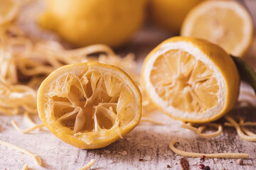 A Squeezed half lemon on a kitchen table with tagliolini pasta  in the background