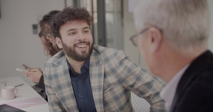 Young male colleagues listening carefully to what the senior manager is saying while he nods his head