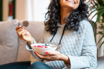 Woman drinking organic milkshake of blueberries, bananas and raspberries