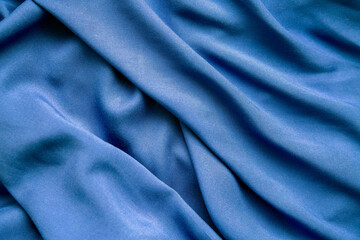 Background from blue fabric in folds. The texture of the fabric.