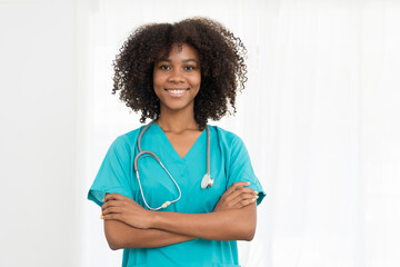 Portrait of smiling young female doctor or young nurse wearing blue scrubs uniform and stethoscope...